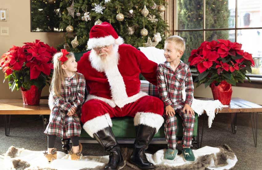 Santa greeting families at Grand Home Furnishings during holiday events.