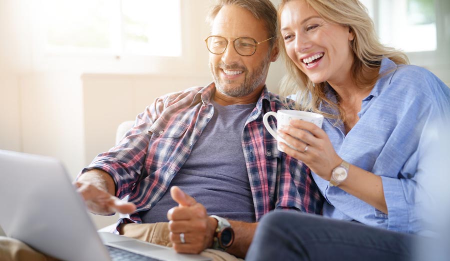 Couple using laptop to apply for a Grand Home Furnishings credit card.